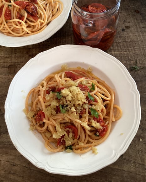 A white plate holds spaghetti with semi-dried tomatoes, herbs, and breadcrumbs, viewed from above. YES it's Rachel Roddy's spaghetti with semi-dried tomatoes, garlic, herbs and breadcrumbs .