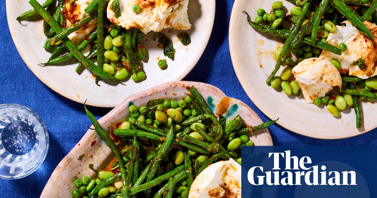 Plates laid out on a table with a blue tablecloth, with the mozzarella and green bean salad on top