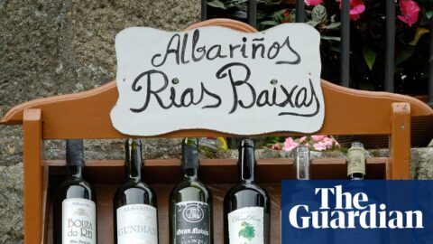 A wooden shelf displays Albariño wine bottles under a hand-painted "Rias Baixas" sign