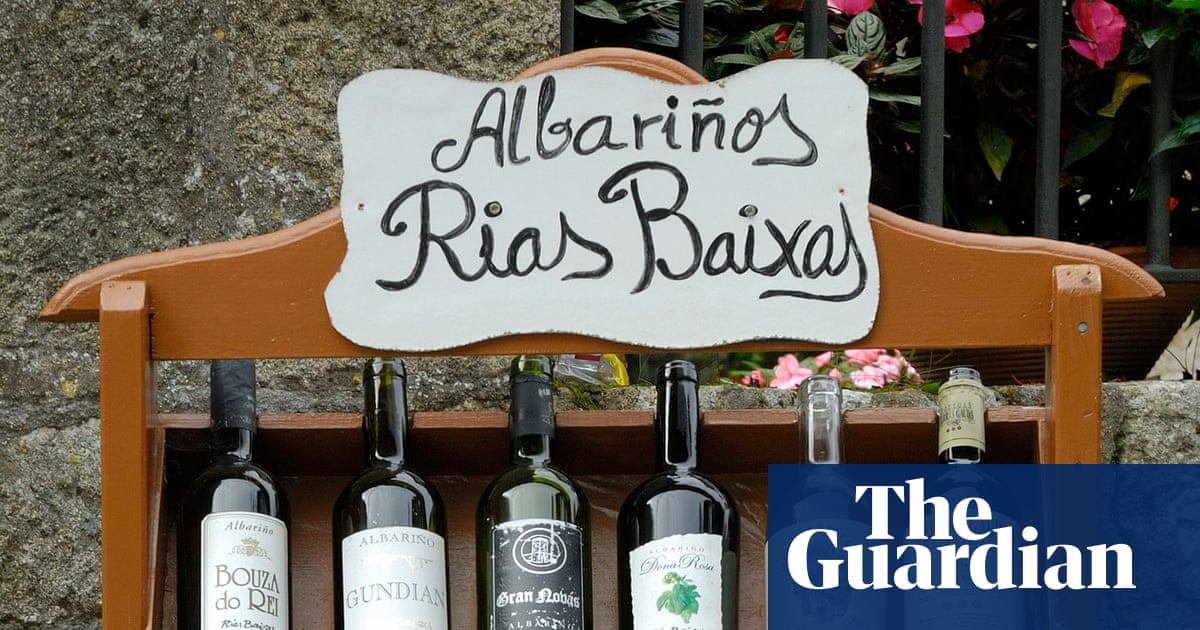 A wooden shelf displays Albariño wine bottles under a hand-painted "Rias Baixas" sign