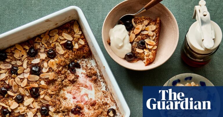 A baking dish of baked oats with cherries and almonds, served in bowls with yoghurt