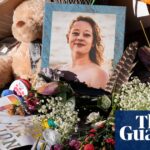 A memorial for Renee Good with flowers, a teddy bear, signs, and her framed photo